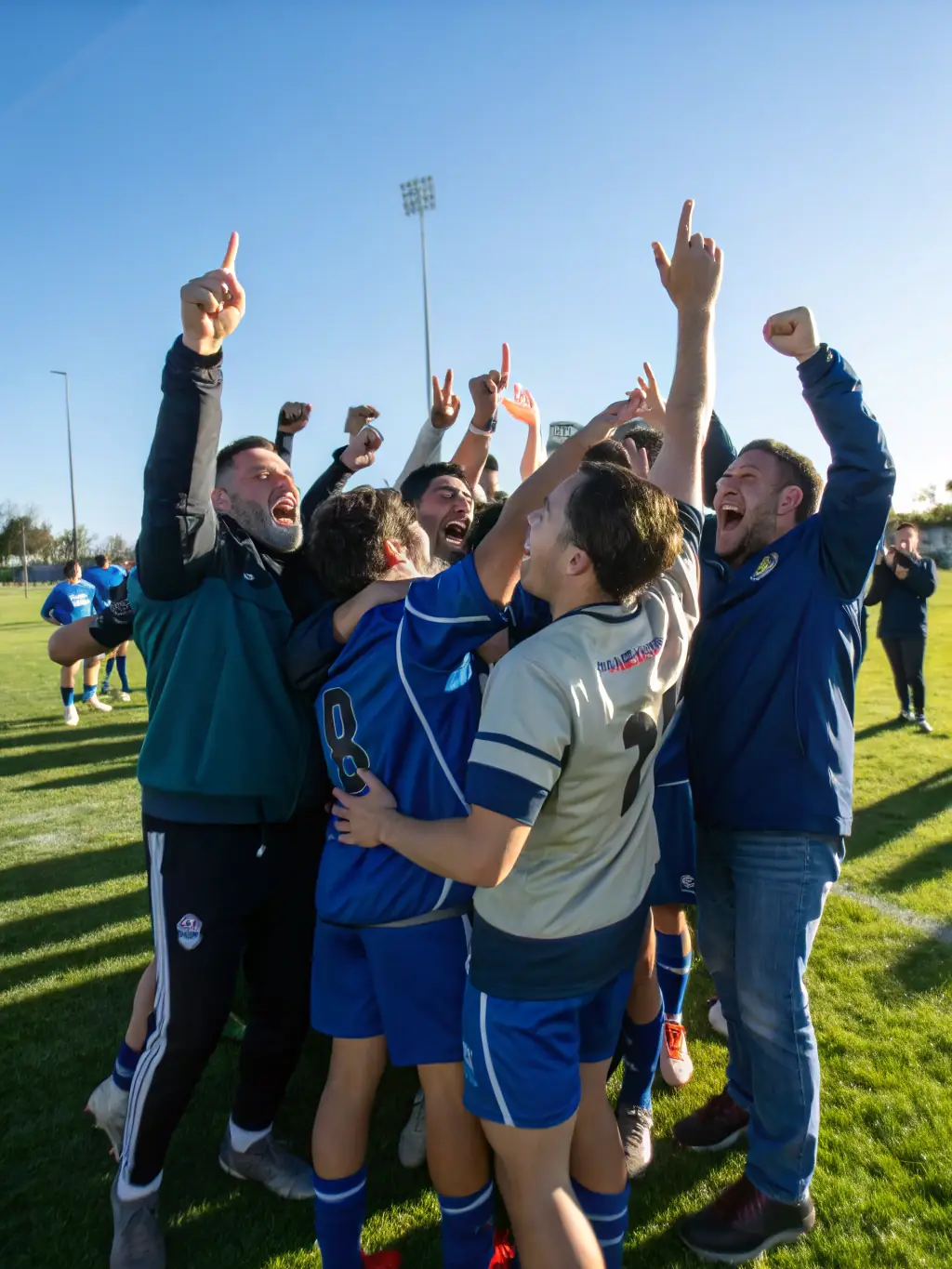 A group of young athletes celebrating a victory, illustrating the positive impact of sports on youth development and teamwork.